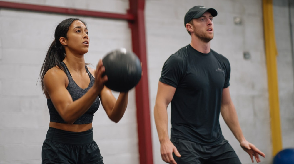 Wysportowana dziewczyna rzuca piłką lekarską