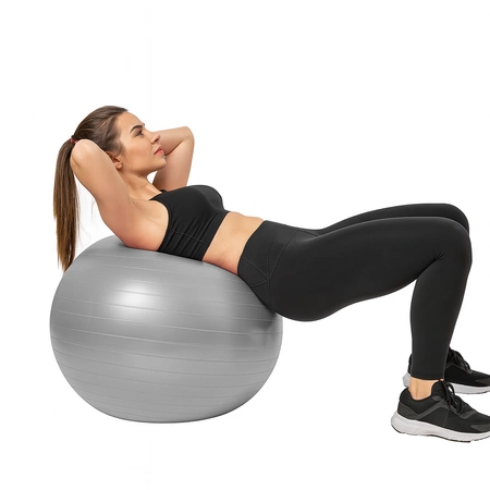 Kobieta ćwicząca na szarej piłce gimnastycznej
