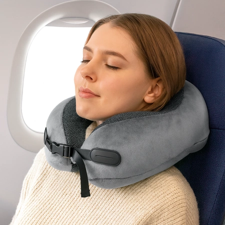 Kobieta w samolocie z szarą poduszką podróżną na szyję z pianki memory foam